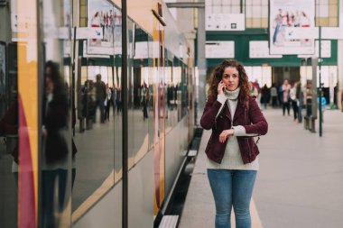 Tren istasyona gelirken bir yolcu telefonda konuşuyor.