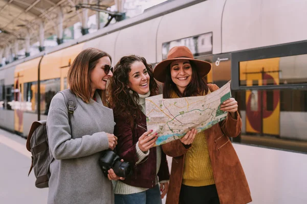 Grupa przyjaciół śmiać patrząc na mapie na stacji — Zdjęcie stockowe