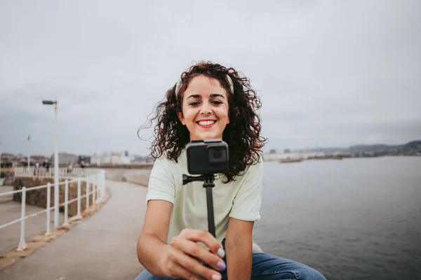 港に座ってスペイン北部の雨の日に写真を撮る美しい若い女性 旅行とテクノロジーライフスタイルのコンセプト — ストック写真