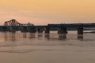 Tren gün batımında Long Bien Köprüsü 'nden geçiyor..