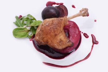 Üstte beyaz bir plaka üzerinde erik ile kavrulmuş ördek bacak. Beyaz üzerinde izolasyonlu