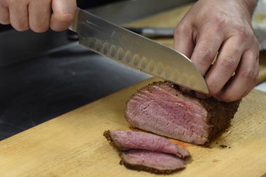 Adam bir ızgaradan pişmiş et keser. El ve bıçak yakın çekim.