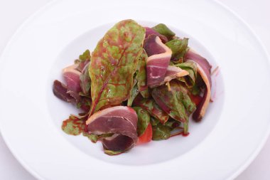 Jambon Jamon ile salata, beyaz plaka üzerinde domates ve yeşillikler