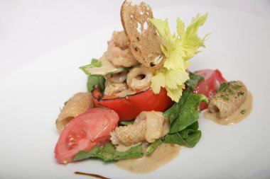 Yararlı, kalamar diyet salata, karides ve soslu ızgara sebze. Çok güzel servis edişim. Beyaz arka plan üzerinde beyaz plaka üzerinde yakın çekim