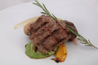 Biberiye yapraklı ve soslu orta pişmiş biftek..