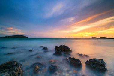 Long exposure shot of rocks on the sea at sunset clipart