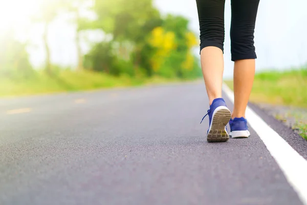 公園の外の道路で実行されている女性ランナーで歩く女性の足 — ストック写真