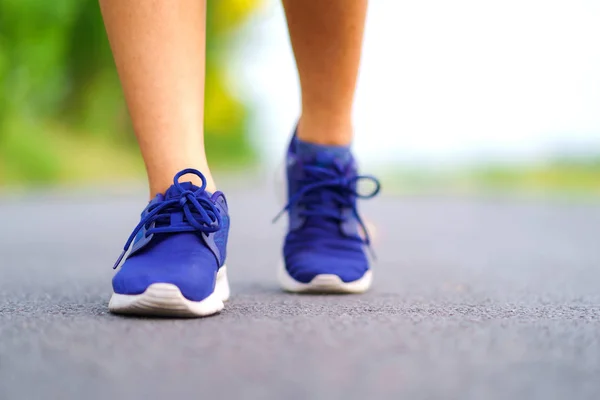 公園の外の道路で実行されている女性ランナーで歩く女性の足 — ストック写真