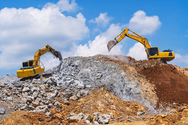 Excavators and stone crushing machine of mining under a blue sky