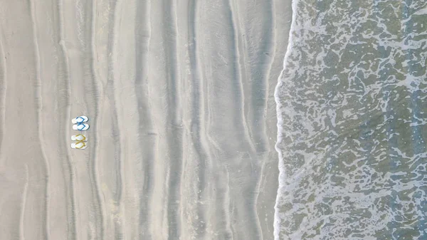 Chanclas en la playa de arena, Fondo de vacaciones de verano, Parte superior aérea — Foto de Stock