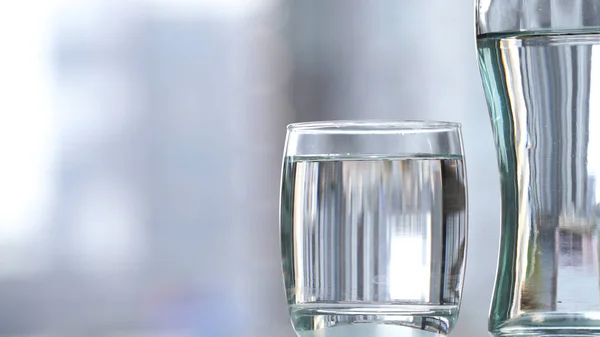 Пейте воду в стекле на столе — стоковое фото