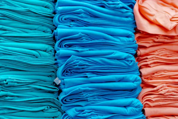 Κοντινό διάγραμμα πολύχρωμα t-shirt στοιβάζονται στα ράφια — Φωτογραφία Αρχείου
