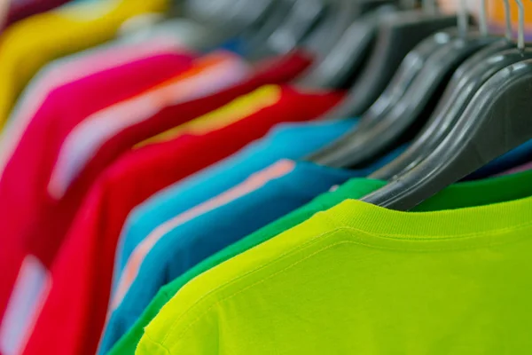 Close up de t-shirts coloridas em cabides — Fotografia de Stock