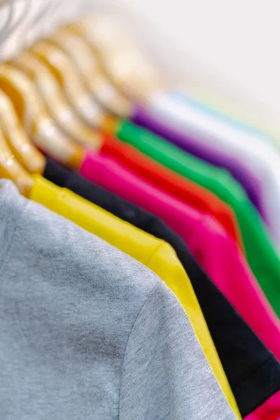 Close up de t-shirts coloridas em cabides — Fotografia de Stock