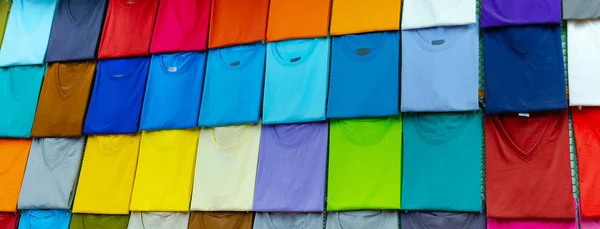 Крупный план красочных футболок на вешалках — стоковое фото