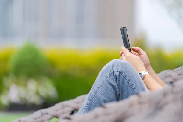 Man relaxing and using smartphone in city park — Stock Photo, Image