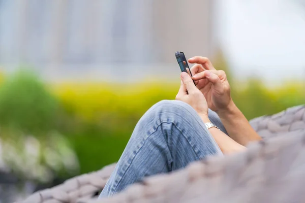 Man relaxing and using smartphone in city park — Stock Photo, Image
