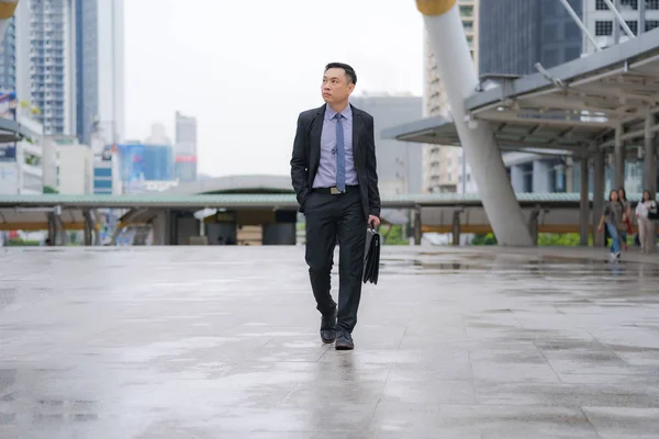 Asiatico businessman walking and holding valigetta con business di — Foto Stock