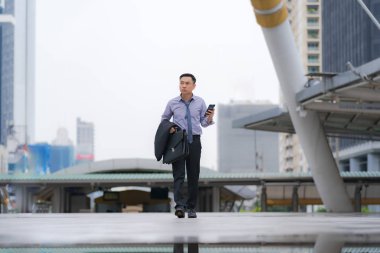 Asyalı İşadamı yürüyüş ve iş ile evrak çantası tutan