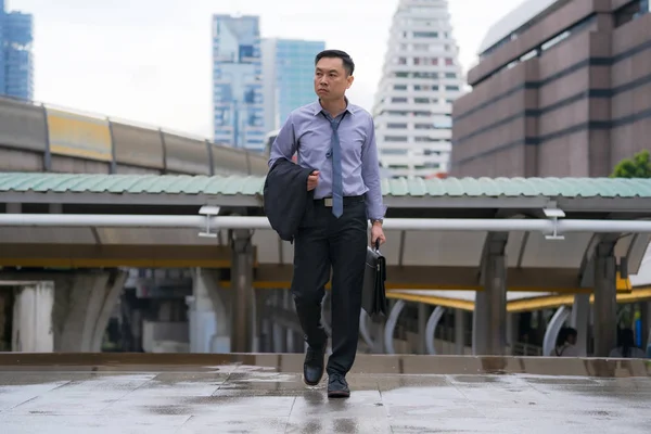 Asiatico businessman walking and holding valigetta con business di — Foto Stock