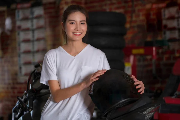 Bella ragazza e un casco moto con backgroun moto — Foto Stock