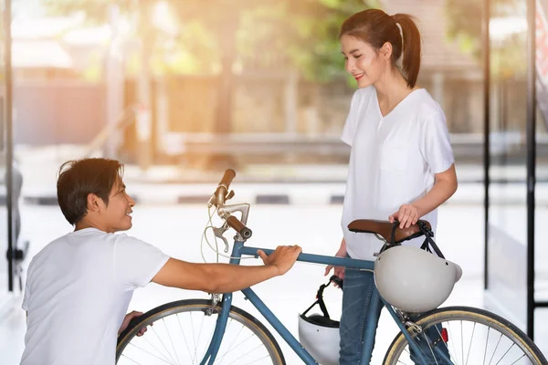 Glückliches Paar, das zu Hause vor der Tür steht und das Fahrrad kontrolliert — Stockfoto
