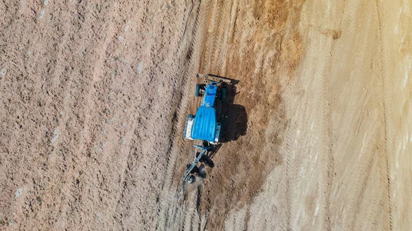 Vista superior dos veículos tratores agrícolas que trabalham no campo — Fotografia de Stock