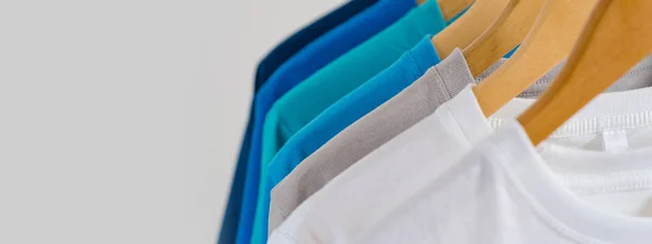Primer plano de camisetas coloridas en perchas, fondo de ropa — Foto de Stock