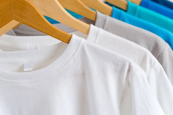 Close up of Colorful t-shirts on hangers, apparel background — Stock Photo, Image