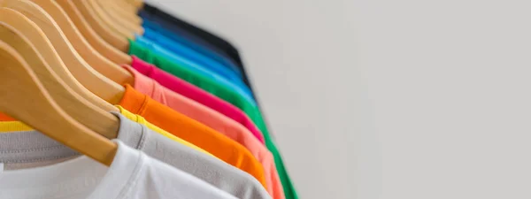 Primer plano de camisetas coloridas en perchas, fondo de ropa —  Fotos de Stock