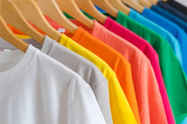 Close up of Colorful t-shirts on hangers, apparel background — Stock Photo, Image