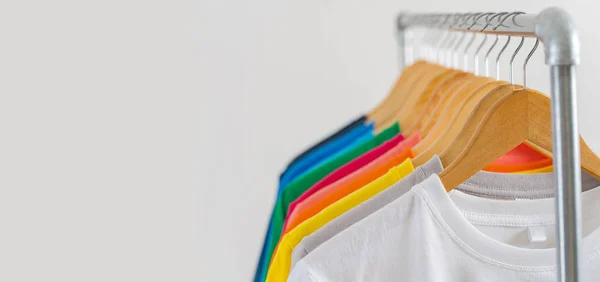 Színes pólók közelsége vállfán, ruházati háttér — Stock Fotó