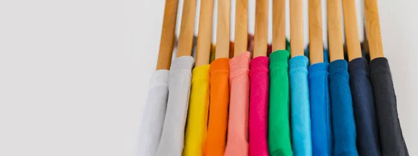 Närbild av färgglada t-shirts på hängare, kläder bakgrund — Stockfoto