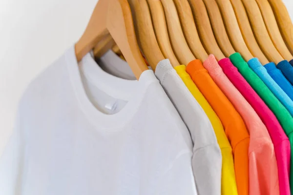 Close up de t-shirts coloridas em cabides, fundo de vestuário — Fotografia de Stock