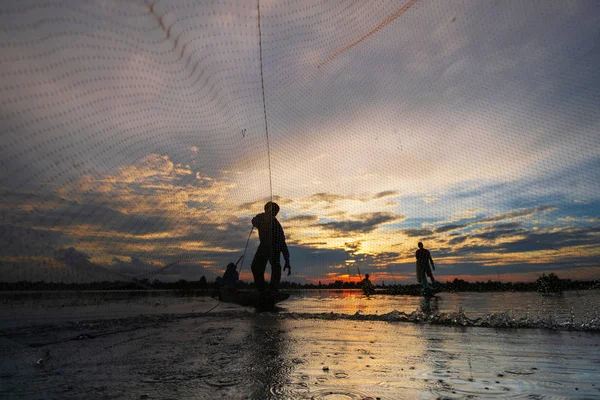 Silueta del pescador en barco de pesca con red en el lago en —  Fotos de Stock