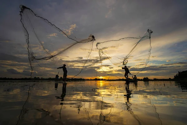 Silhouette of Fisherman a halászhajón hálóval a tavon a — Stock Fotó