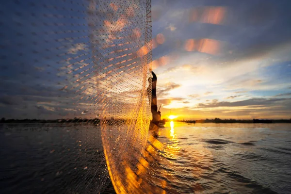 Silhouette of Fisherman a halászhajón hálóval a tavon a — Stock Fotó