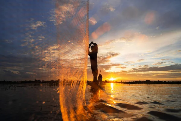 Silhouette eines Fischers auf einem Fischerboot mit Netz auf dem See bei — Stockfoto