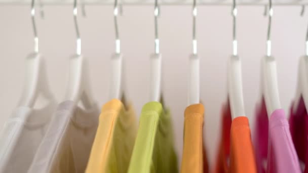 ハンガーの上のカラフルなTシャツの閉まり アパレルの背景 スライダーショット — ストック動画