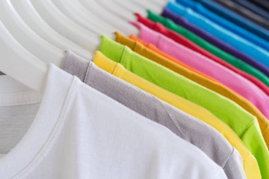Tişörtleri kapatın, beyaz arka plandaki askıları giyin.