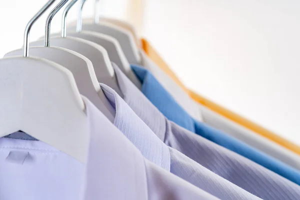 Close Up of Men\'s dress shirts, Clothes on hangers on white background