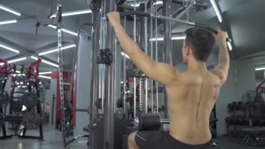 Sportif adam spor salonunda egzersiz yapıyor.