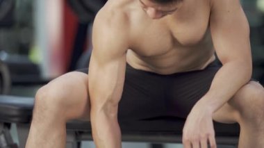 Spor salonunda halterli adam eğitimi.