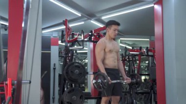 Spor salonunda halterli sporcu eğitimi.