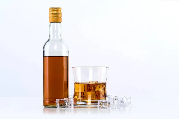 白底威士忌加冰块和瓶子的杯子 — 图库照片