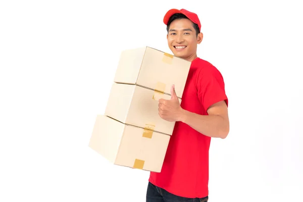 身穿红帽空白T恤制服的送货员站在白色背景的包裹邮筒旁微笑 — 图库照片