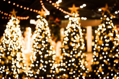 Altın bokeh ışık arka plan ile Noel ağacı. Xmas soyut bulanıklık ve parlayan süslemeleri açık havada.
