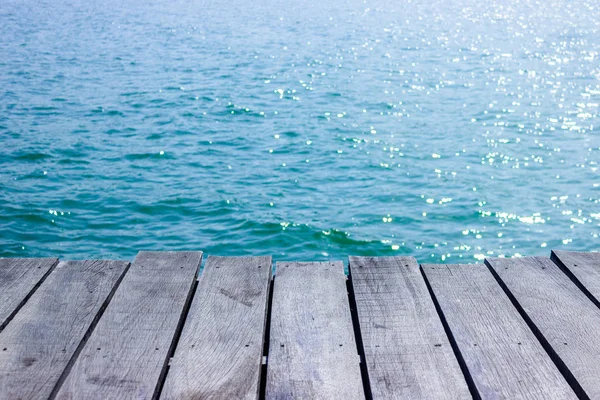 木製テーブル トップ青い海背景付き — ストック写真