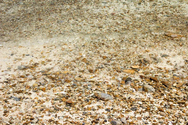 Ondes douces avec mousse d'eau sur galets et plage de sable . — Photo