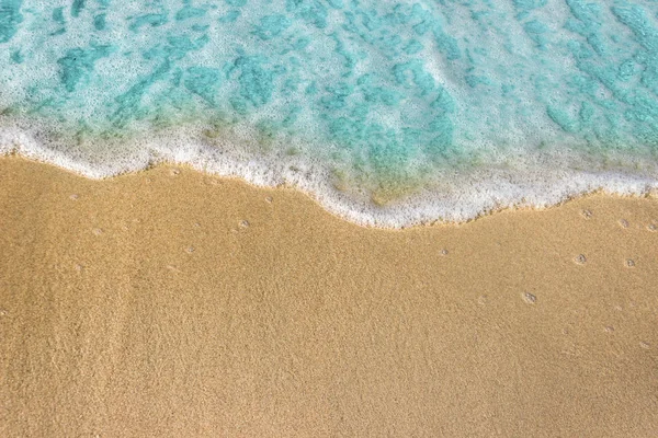 Zachte blauwe golven met schuim van de oceaan op het zandstrand achtergrond — Stockfoto